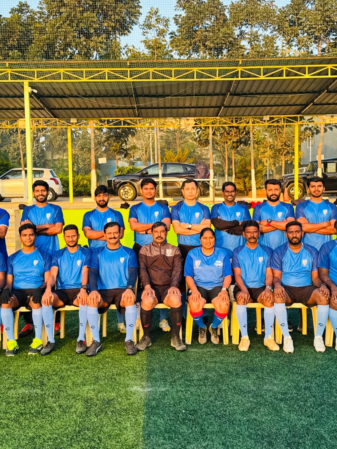 BPSS coaching staff and young football players gathered on a Bengaluru football pitch during a training session
