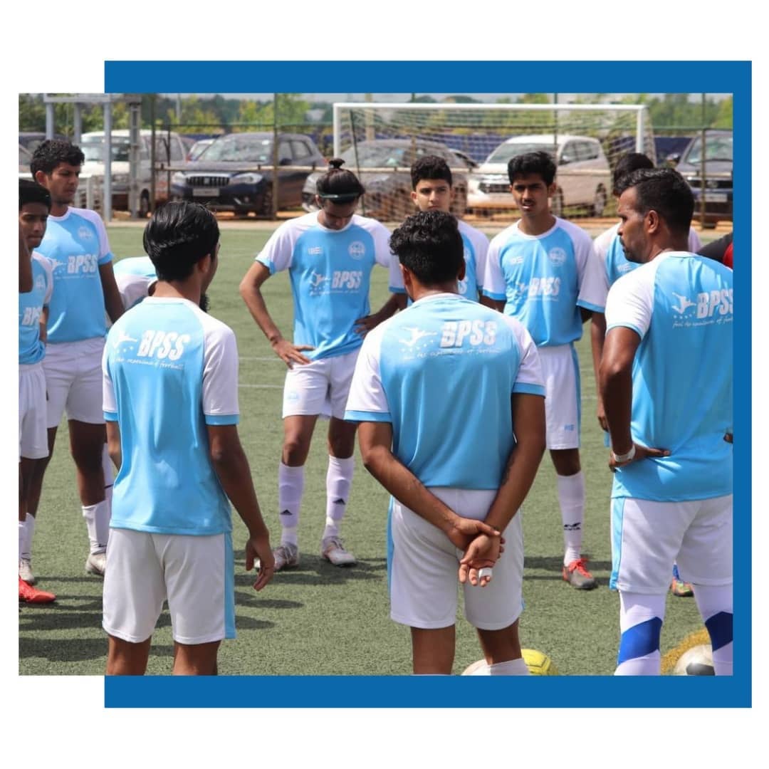 BPSS head coach demonstrating ball control technique to a group of attentive young players