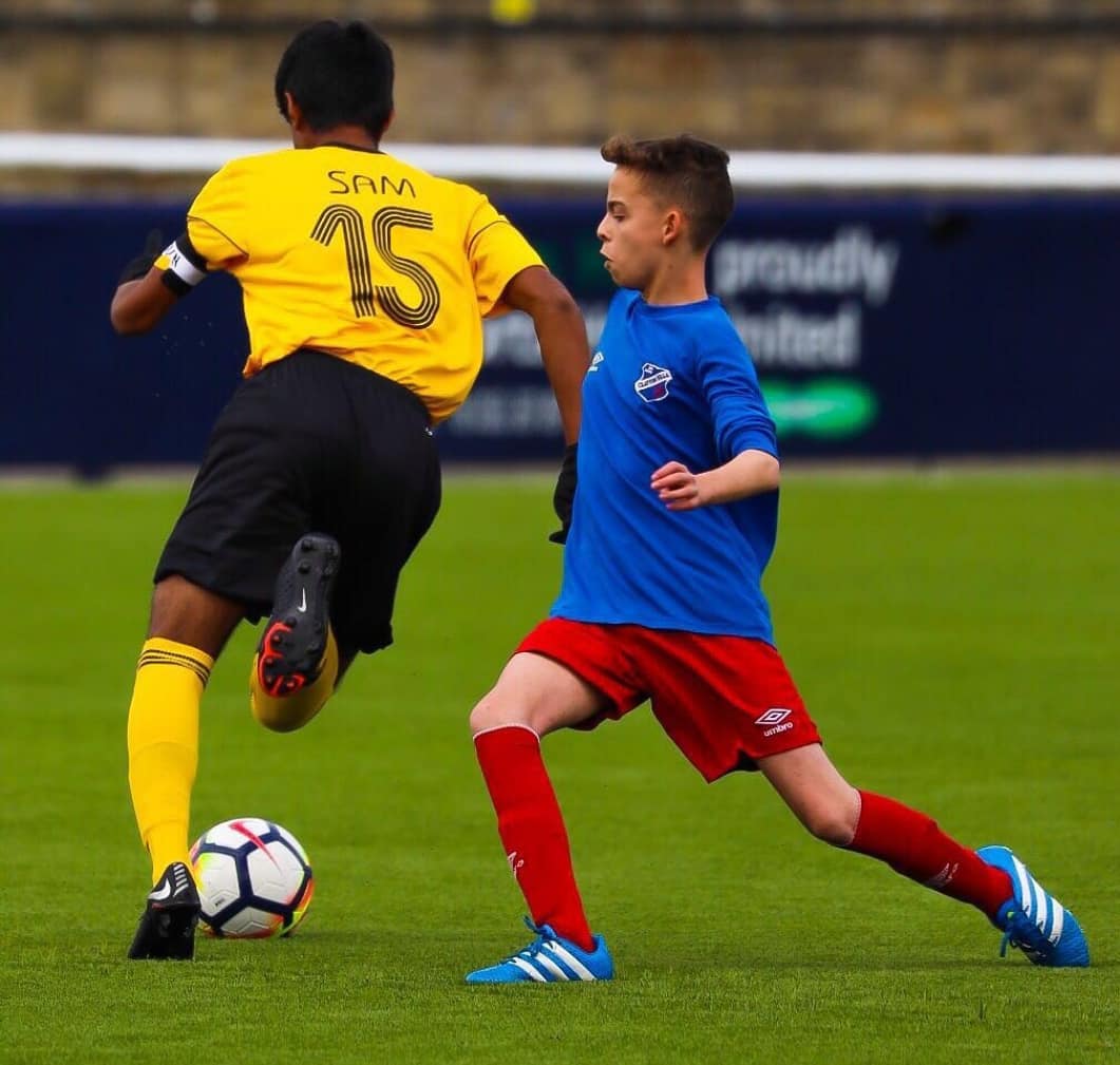 BPSS player taking a corner kick while teammates position themselves in the penalty area